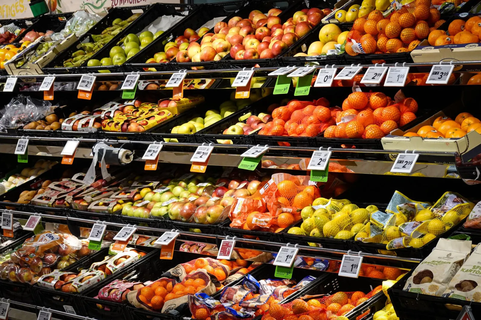 Colorful assortment of fresh fruits neatly arranged on supermarket shelves, ideal for healthy eating themes.